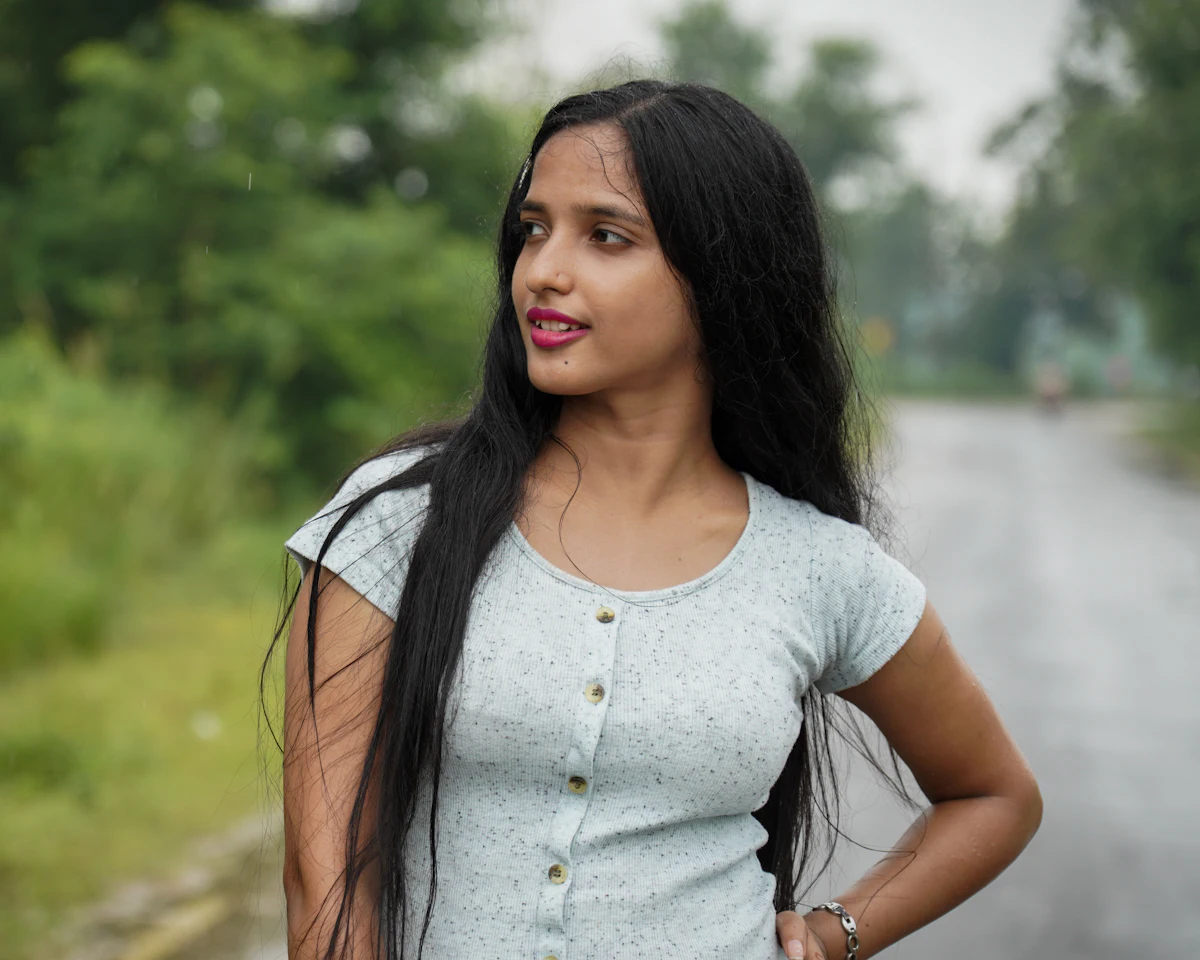A young woman standing outdoors on a green field